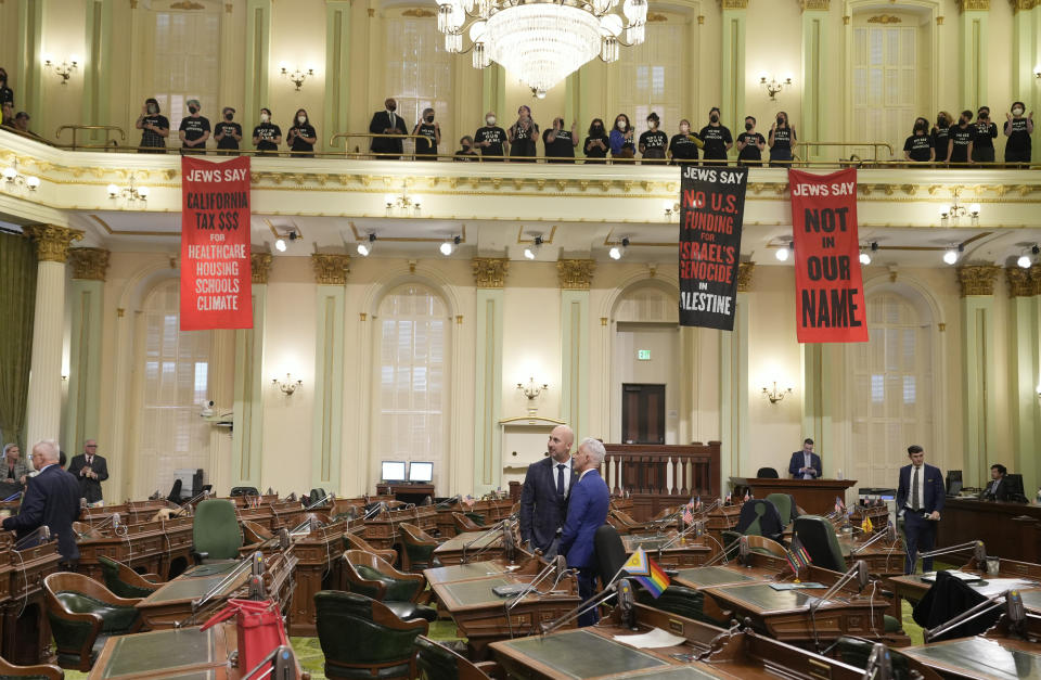 Assembly members Heath Flora, R-Modesto, left, and Josh Lowenthal, D-Long Beach, right, leave the Assembly chambers as protesters call for a cease-fire in Gaza disrupt the first day of the California legislative session in Sacramento, Calif., Wednesday, Jan. 3, 2024. The Assembly session was just getting started when protesters wearing matching black t-shirts stood up in the gallery and started singing "Cease-fire now" and "Let Gaza Live." The Assembly adjourned the session.(AP Photo/Rich Pedroncelli)