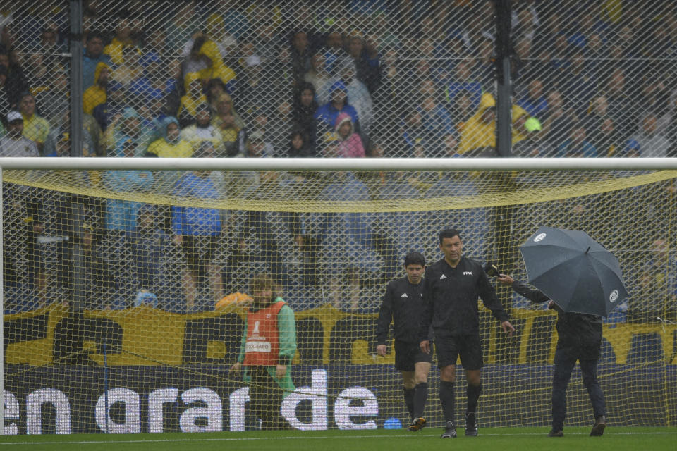 El árbitro Roberto Tobar revisa el estado de la cancha en el estadio la Bombonera en Buenos Aires, Argentina, el sábado 10 de noviembre de 2018. El partido de ida de la final de la Copa Libertadores entre Boca Juniors y River Plate fue pospuesto por la lluvia. (AP Foto/Gustavo Garello)