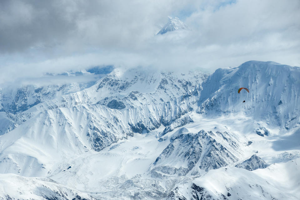 &ldquo;I was incredibly focused on flying well, as we needed to stay in the air and make distance,&rdquo; says Gavin McClurg, pictured here during the first ever traverse of the Alaska Range by foot and paraglider. &ldquo;This had been a dream of mine for six years&mdash;to fly across the most remote and iconic mountains in North America.&rdquo; The attempt didn&rsquo;t start out well, however. Bad weather kept McClurg and his expedition partner, Dave Turner, pinned down in their tents for more than a week before being able to get airborne. But finally, &ldquo;some of the clouds cleared and I had a perfect view of Denali, the highest mountain in North America,&rdquo; he says. &ldquo;I felt like we were pulling off something completely absurd and really special, and not likely to be repeated for a long time. In short, I was totally blown away.&rdquo; Photographer Jody MacDonald, who shot this image of McClurg&nbsp;flying past&nbsp;Mount Foraker and Mount Denali, about 37 miles into his 124-mile route over Denali National Park,&nbsp;was just as excited. &ldquo;There was a lot of pressure for them to fly as far as they could through the park,&rdquo; she says, because they weren&rsquo;t allowed to land or take off anywhere inside the park. &ldquo;The clouds were developing more and more by the minute, but they were able to fly around the clouds against an unbelievable background.&rdquo; MacDonald says that McClurg&rsquo;s dream of making the traverse was the result of careful planning and ambition. &ldquo;There have been only two other documented traverses: one by foot, and one by foot and pack raft. Paragliding in the Alaska Range had never been done, and traversing the entire range, from one extreme end to the other, was pretty audacious.&rdquo; About halfway through the expedition, Turner and an accompanying film crew departed, leaving McClurg completely alone and facing miles of bushwhacking through dangerous terrain toward his goal. &ldquo;The closest call during this section was crossing the Gakona River, which comes out of the Gakona Glacier. I had to forge 10 miles upriver along the banks, following a grizzly trail, because the river was much too deep and fast to cross on foot,&rdquo; he says. Eventually he crossed via an ice bridge, &ldquo;but the footing, due to the hard ice and talus, was treacherous. One slip and I would have plummeted several hundred feet into the icy river and had very little chance of&nbsp;survival.&rdquo; Thirty-seven days after launching his attempt, McClurg completed the traverse without any serious injuries. &ldquo;His vision and determination to make this happen and suffer it out was amazing to witness,&rdquo; MacDonald says. McClurg adds: &ldquo;Even on the really physical or scary days, life was so wonderfully simple. You wake up, you eat and have coffee, and then your whole job for the day is just to stay alive.&rdquo;