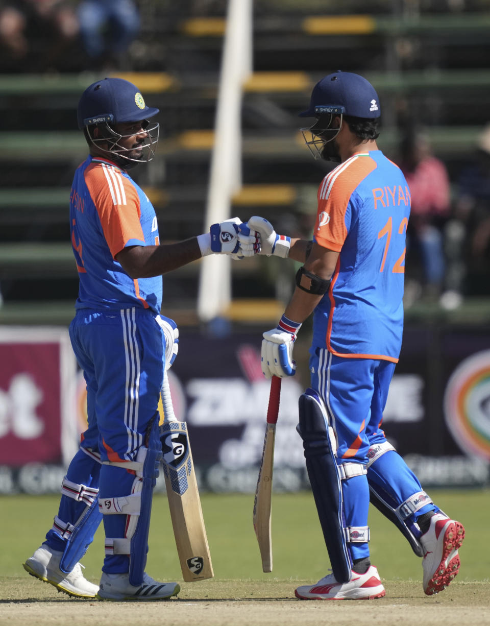 Indian batsman Sanju Samson, left, and Ryan Paraga touch gloves during the T20 cricket match between Zimbabwe and India at the Harare Sports club, in Harare, Sunday, July 14, 2024. (AP Photo/Tsvangirayi Mukwazhi)