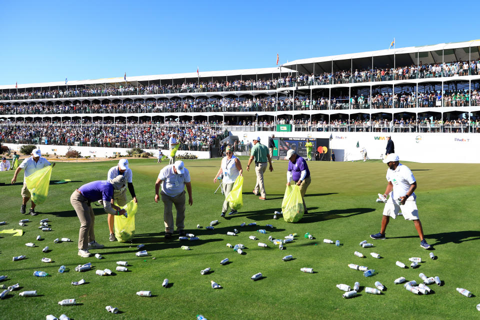 Groundskeepers, pictured here picking up bottles thrown from the stands on the 16th hole at the Phoenix Open.