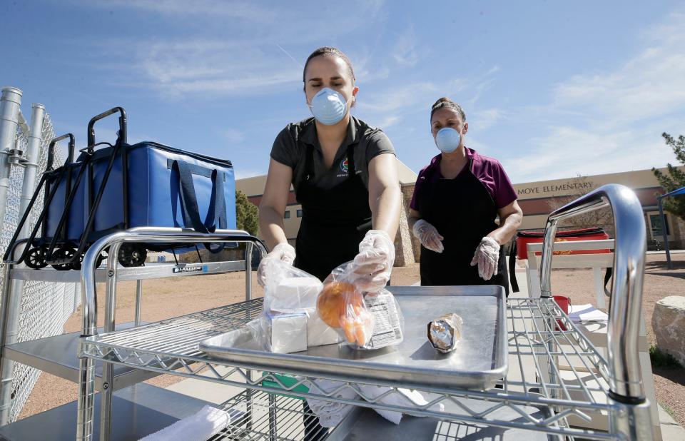 Nancy Nuñez and Licha Escalera prepare a tray of food for drive-up service Monday, March 23, 2020, at Moye Elementary School.