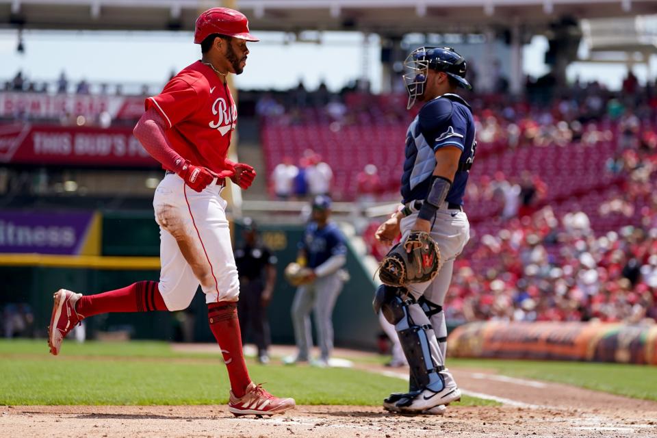 Cincinnati Reds left fielder Tommy Pham (28) scores on an errant throw by Tampa Bay Rays catcher Rene Pinto (50) during the third inning of a baseball game, Sunday, July 10, 2022, at Great American Ball Park in Cincinnati.