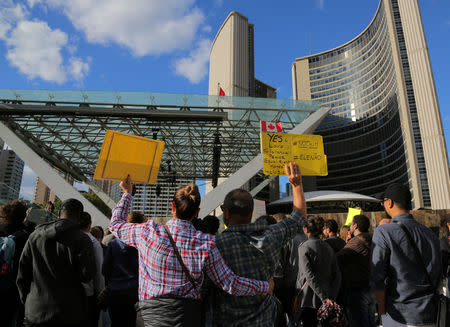 People hold signs during a protest against Brazilian presidential candidate Jair Bolsonaro ahead of the country's elections, outside city hall in Toronto, Ontario, Canada September 29, 2018. REUTERS/Chris Helgren