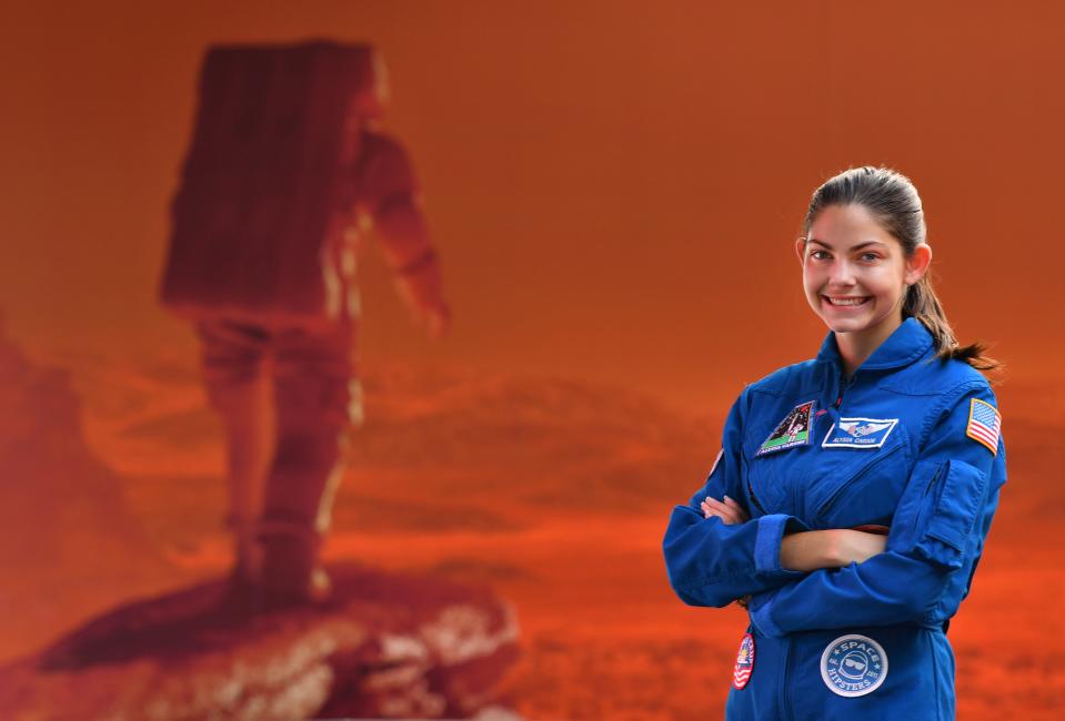 Alyssa Carson standing in front of a Mars mural at the Kennedy Space Center Visitor Complex. Carson, 18-year-old Florida Tech student, has known she wanted to be an astronaut from a very young age and has been working towards that goal since childhood.