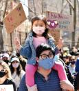 <p>A man and his daughter, who holds up homemade signs, protest together at the Rally Against Hate in N.Y.C. on March 21.</p>