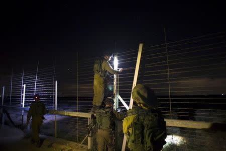 Israeli soldiers repair a malfunction in Israel's border fence with southern Gaza July 8, 2015. REUTERS/Ronen Zvulun