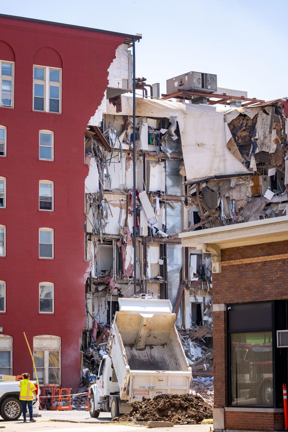 Workers secure the area on Monday, May 29, 2023, a day after an apartment building partially collapsed in Davenport.