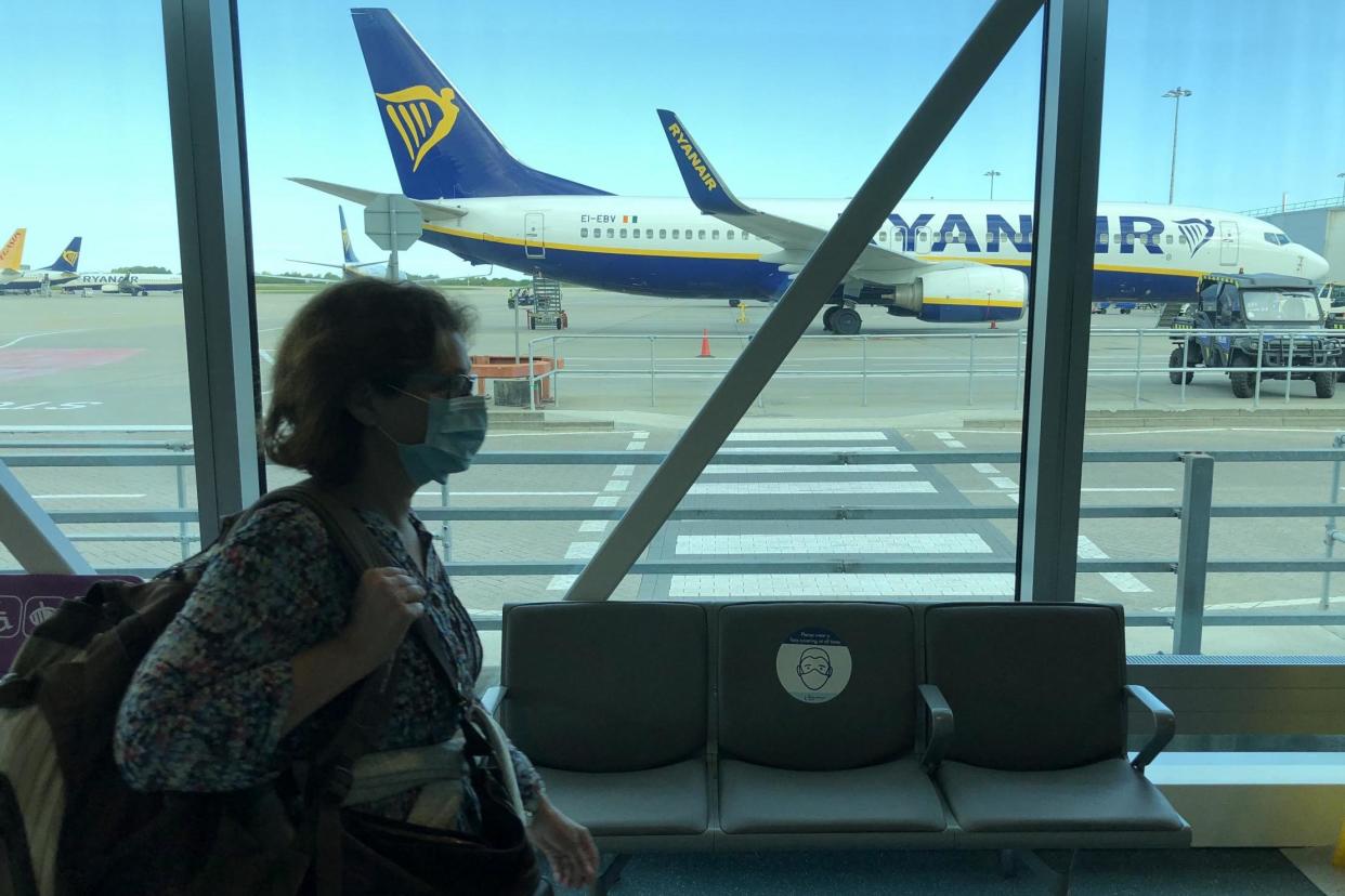 New normal: a passenger wearing a mask at Stansted airport: Simon Calder