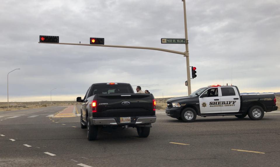 A Sandoval County sheriff's deputy stops a motorist near Sue Cleveland High School in Rio Rancho, N.M. on Thursday, Feb. 14, 2019. Rio Rancho police say a gunshot was fired at the high school in that Albuquerque suburb but that nobody was injured and that one person is in custody. (AP Photo/Russell Contreras)