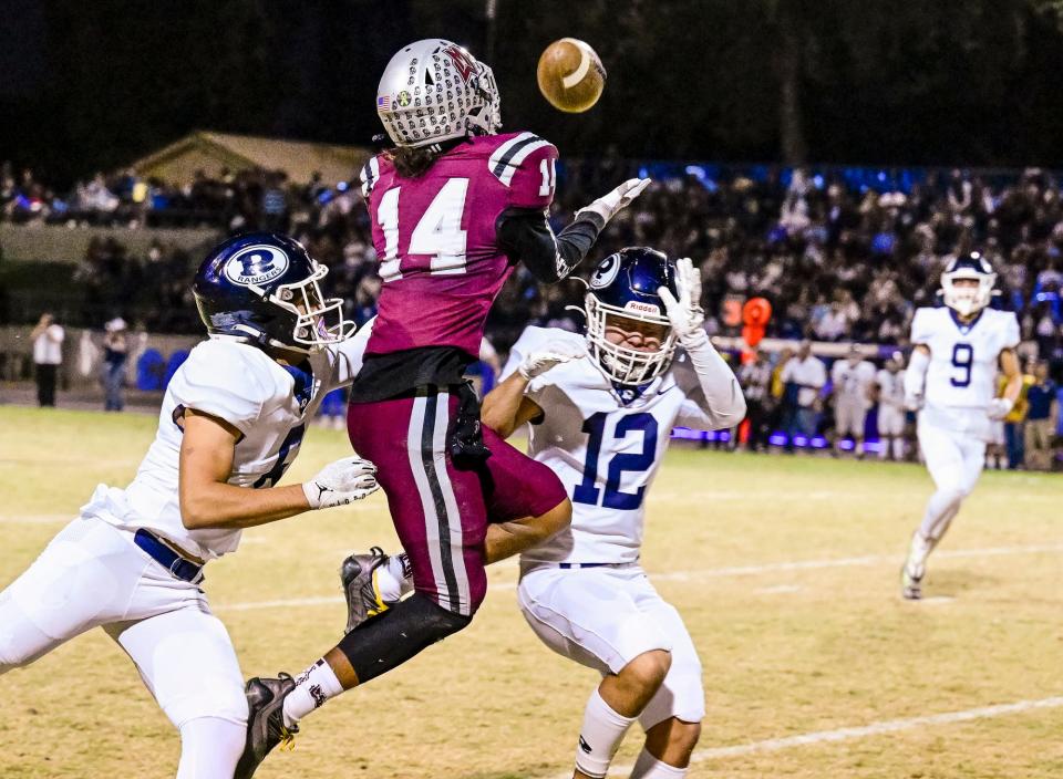Redwood's Ambrose Bueno, left, and Redwood's Will Kennedy break up a pass intended for Mt. Whitney's Israel Briggs in the 67th annual Cowhide rivalry game Friday, October 28, 2022.