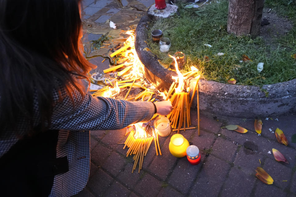 People light candles for the victims near the Vladislav Ribnikar school in Belgrade, Serbia, Wednesday, May 3, 2023. Police say a 13-year-old who opened fire at his school drew sketches of classrooms and made a list of people he intended to target. He killed eight fellow students and a school guard before being arrested. (AP Photo/Darko Vojinovic)