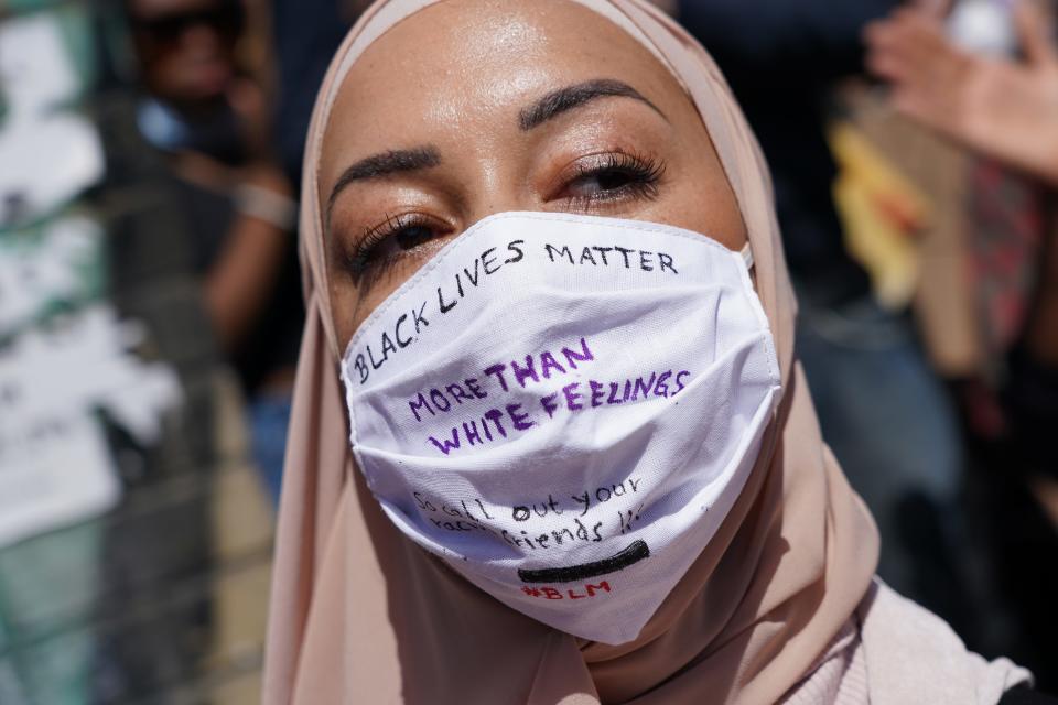 A Muslim woman wears a face mask that reads, "Black lives matter more than white feelings" at a protest rally against racism May 31 in Berlin after the death of George Floyd in the USA.