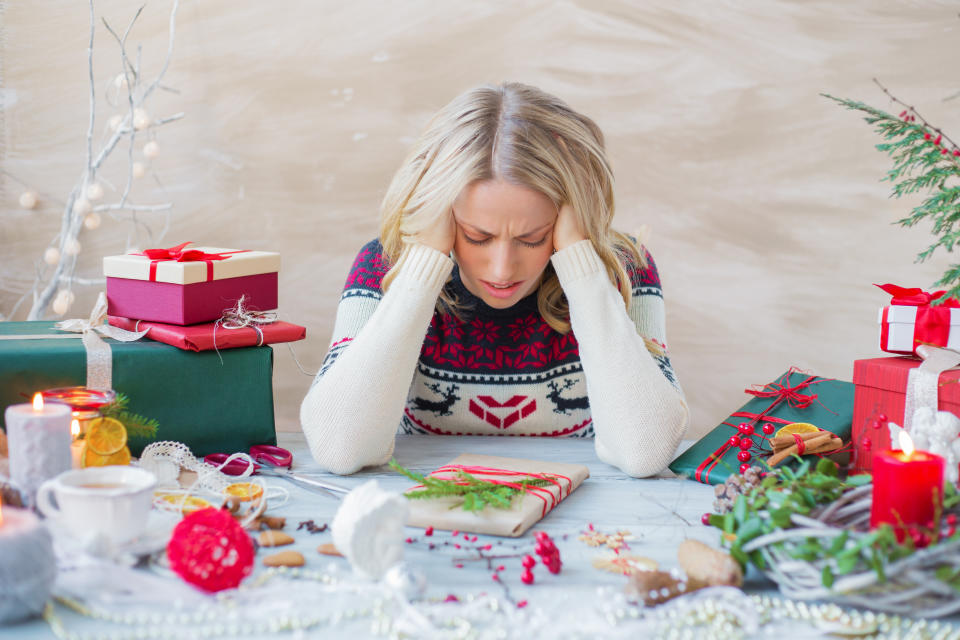 Exhausted and overwhelmed woman packing Christmas gifts