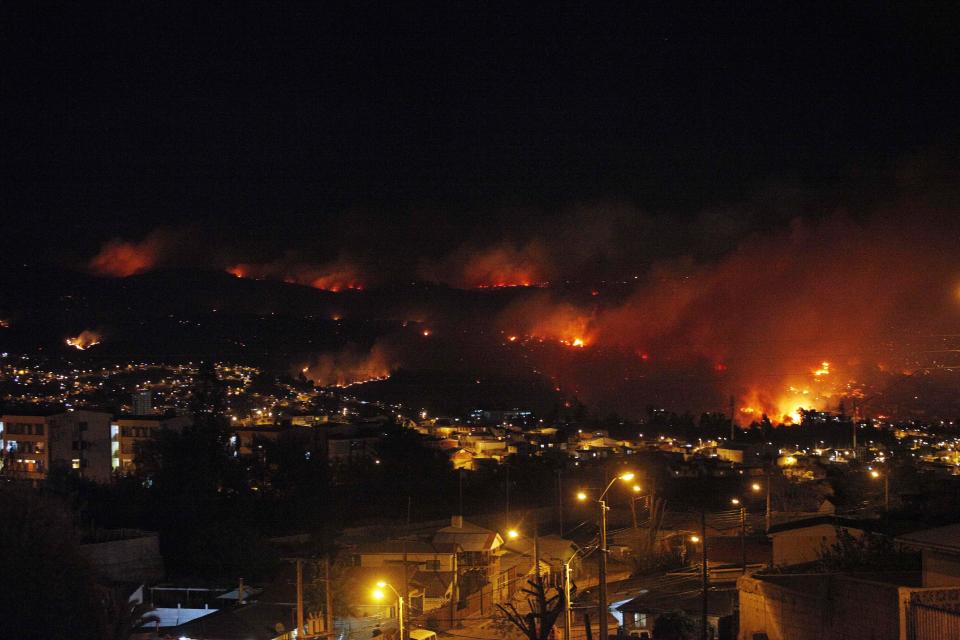 An out of control forest fire rages towards urban areas in the city of Valparaiso, Chile, Saturday, April 12, 2014. Authorities say the forest fire has destroyed at least 150 homes and is forcing evacuations. ( AP Photo/ Luis Hidalgo)