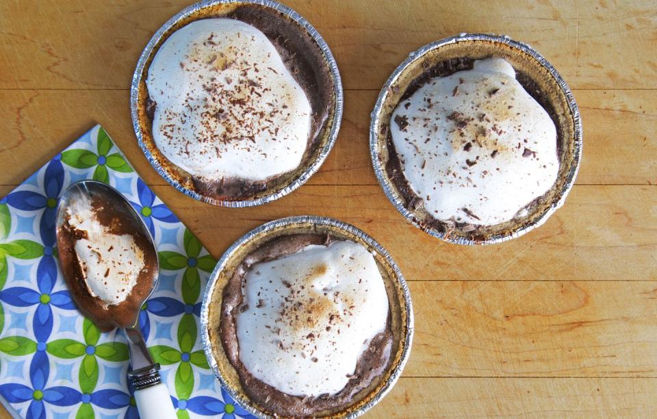 <p>Spread two scoops soft chocolate ice cream in mini graham cracker crusts. Freeze at least 1 hour or until firm. Spread about 1/4 cup marshmallow crème on each; place under broiler 2–4 minutes, or until crème turns golden brown. Top with shaved chocolate. Return to freezer until ready to serve.</p>