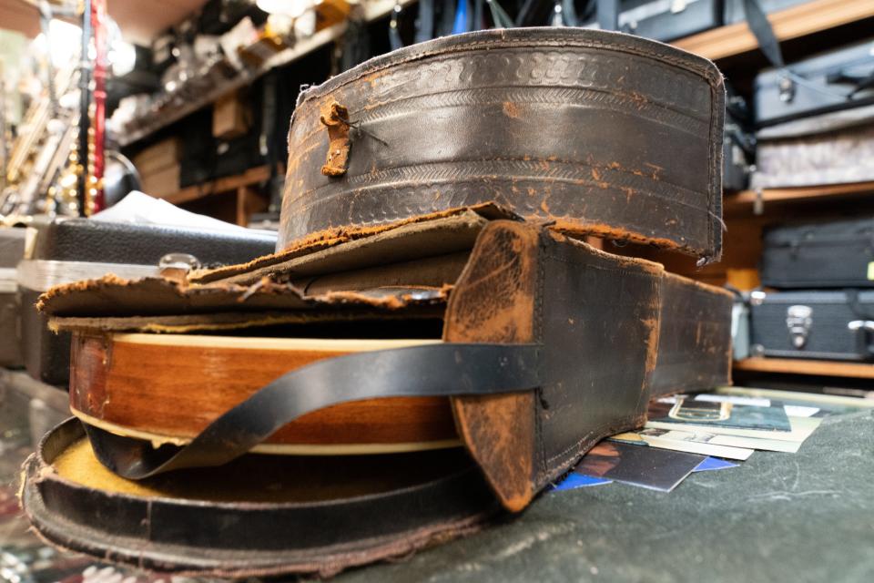 An original leather-bound case for a Shutt mandolin shows wear as it surrounds the instrument it was crafted to protect.