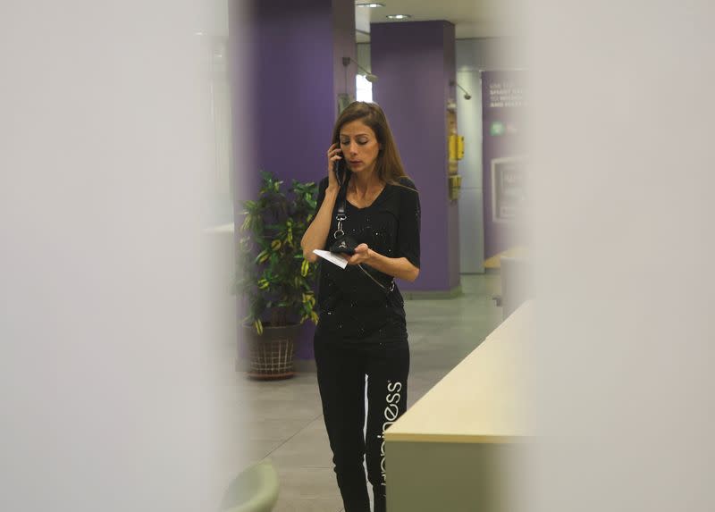 Cynthia Zarazir, a member of the Lebanese parliament uses her phone as she entered a Byblos bank branch seeking her own savings according to a depositors' advocacy group, in Antelias