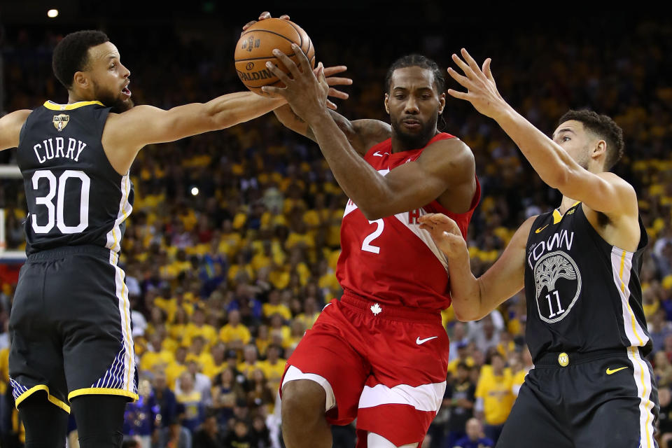 OAKLAND, CALIFORNIA - JUNE 07:  Kawhi Leonard #2 of the Toronto Raptors drives to the basket against Stephen Curry #30 and Klay Thompson #11 of the Golden State Warriors in the second half during Game Four of the 2019 NBA Finals at ORACLE Arena on June 07, 2019 in Oakland, California. NOTE TO USER: User expressly acknowledges and agrees that, by downloading and or using this photograph, User is consenting to the terms and conditions of the Getty Images License Agreement. (Photo by Ezra Shaw/Getty Images)