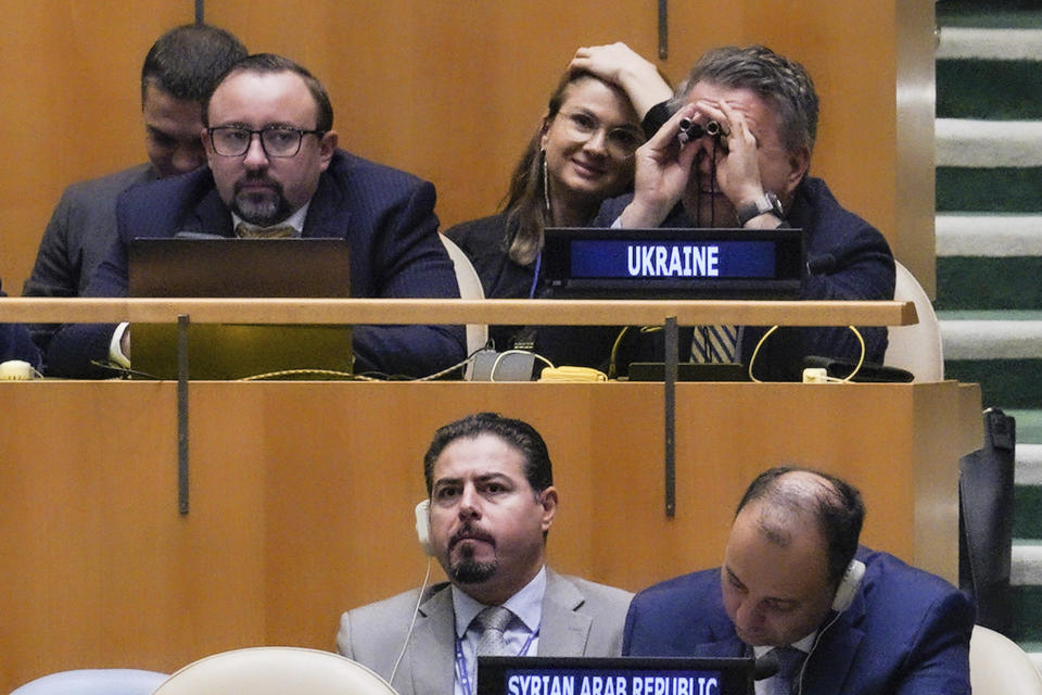 United Nations Ambassador from Ukraine, Sergiy Kyslytsya, far right top, use a binocular in the U.N. General Assembly, before it voted on a resolution condemning Russia's illegal referendum in Ukraine, Wednesday Oct. 12, 2022 at U.N. headquarters. (AP Photo/Bebeto Matthews)