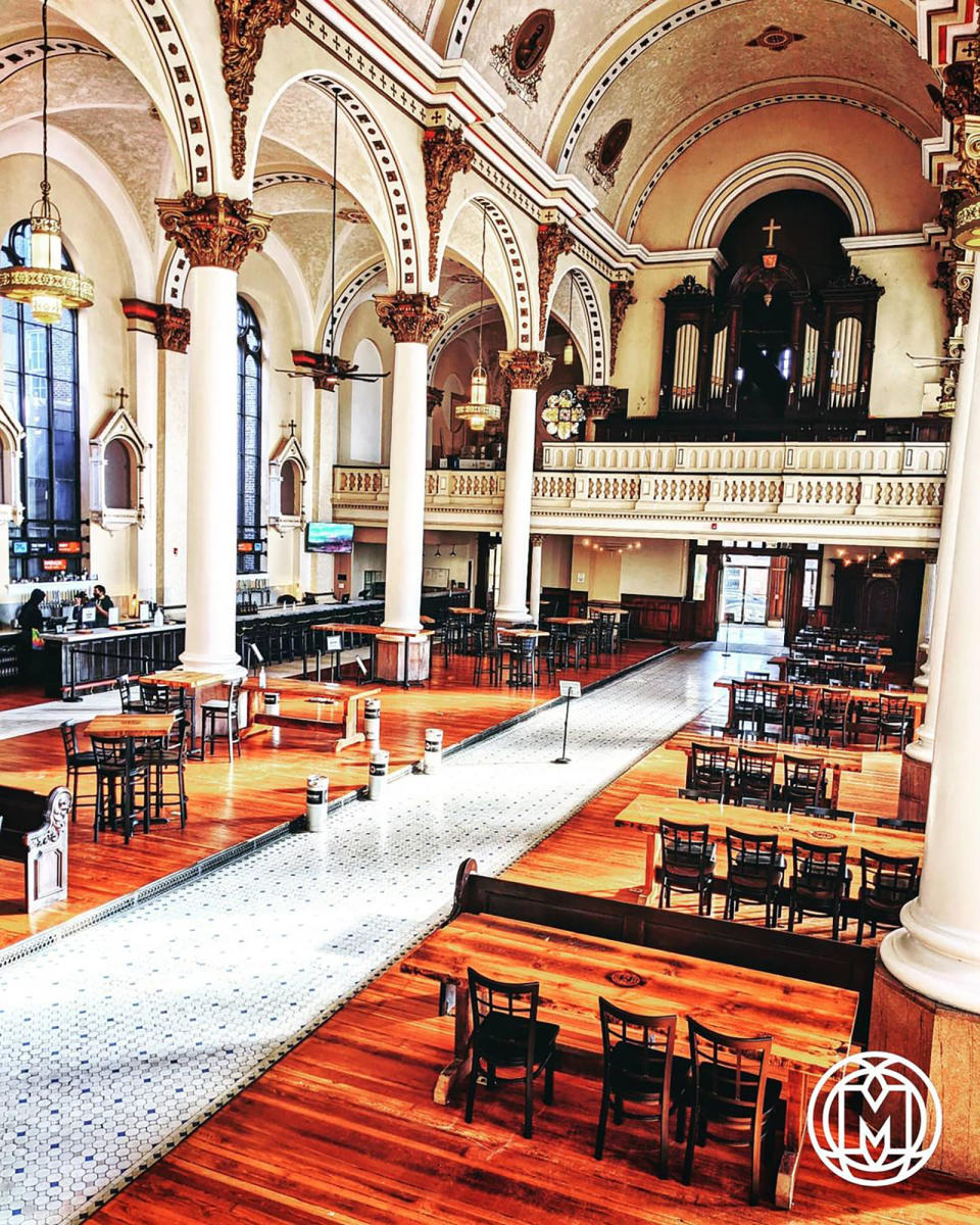 This photo provided by Jon Holley shows the Ministry of Brewing, housed in what was once St. Michael the Archangel Church in Baltimore. The church reopened to the public as a brewery in January 2020, featuring a dazzling interior with soaring columns and a mural-painted barrel ceiling. The brewery also hosts events, fundraisers and even local delegate debates. (Courtesy of Ministry of Brewing via AP)