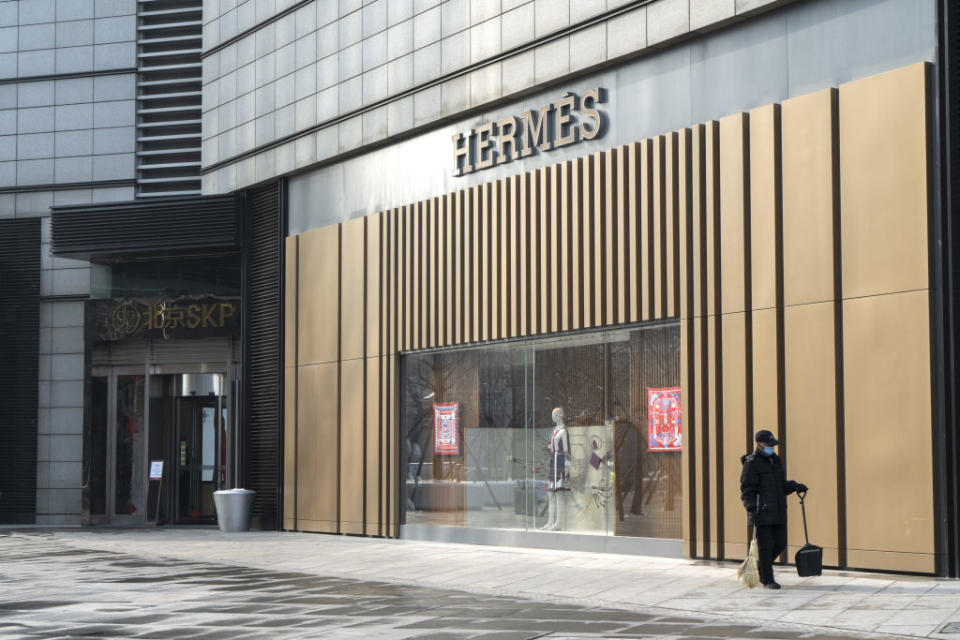 A cleaner walks past an Hermes International SCA store in Beijing, China, on Sunday, Feb. 2, 2020. (Photographer: Giulia Marchi/Bloomberg)