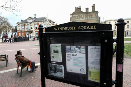 FILE PHOTO: A man sits on a bench next to a sign on Windrush Square in the Brixton district of London, Britain April 16, 2018. REUTERS/Simon Dawson/File Photo