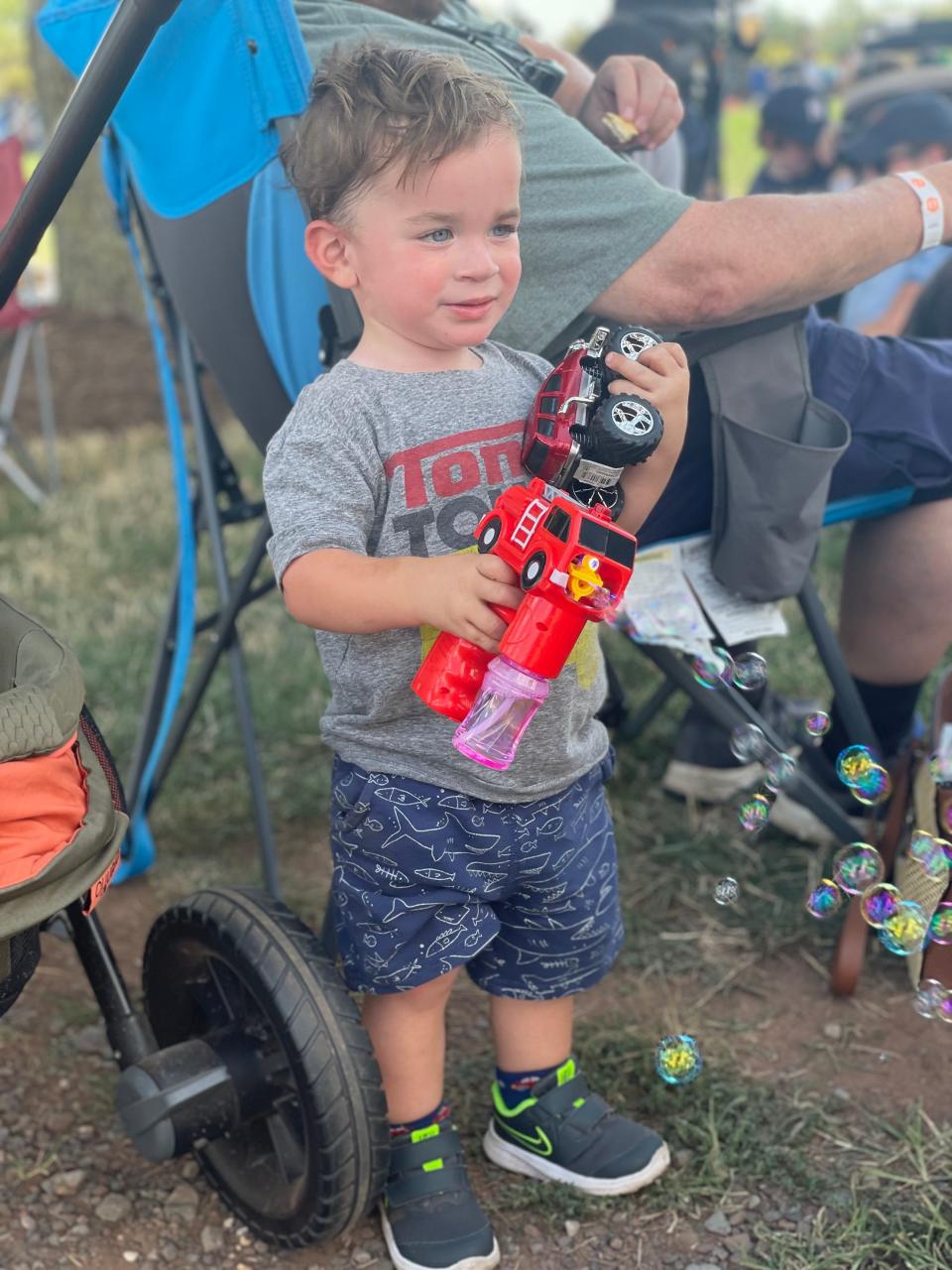 Dax Theodore Babcock holding his beloved toy trucks.  The nearly 3-year-old loved anything with four wheels and an engine.