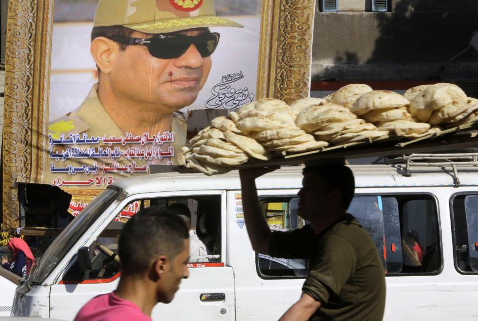 An Egyptian bread vendor rides his bicycle under a giant banner supporting presidential hopeful Abdel-Fattah el-Sissi, the country's former military chief, in Cairo, Egypt, Friday, April 18, 2014. El-Sissi is the most likely winner of next month’s vote. He has enjoyed nationwide support in the nine months since he ousted Islamist President Mohammed Morsi. Many Egyptians see him as a potential savior, delivering the nation of some 90 million people from its seemingly countless woes. (AP Photo/Amr Nabil)