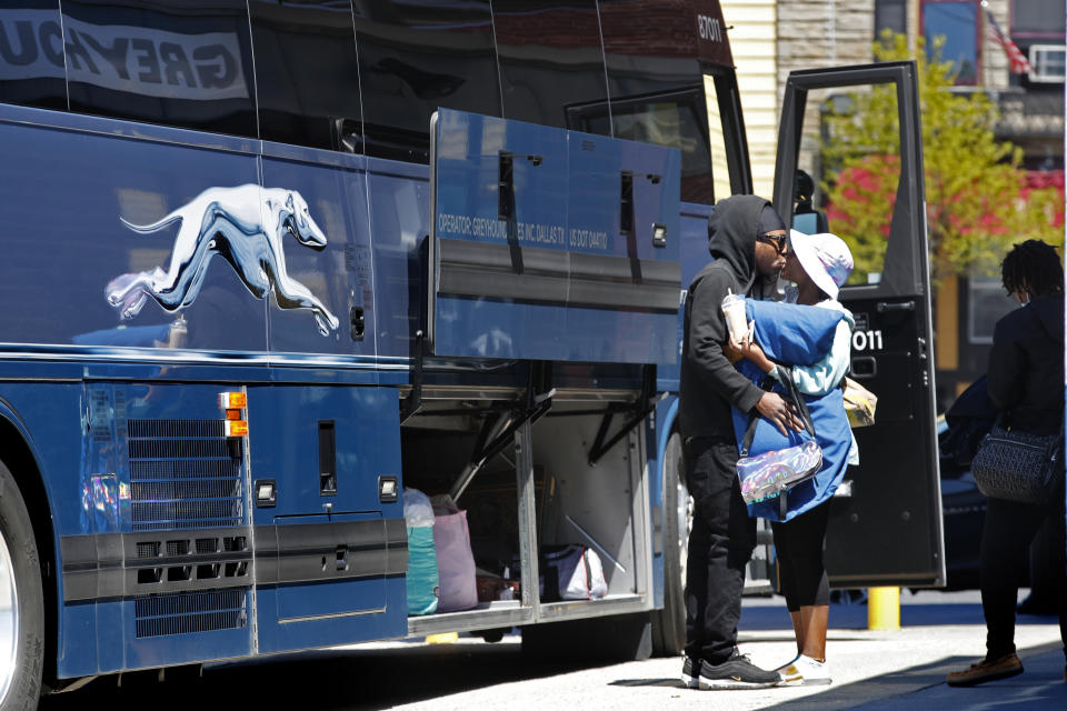 In this Wednesday, May 13, 2020 photo, a man kisses his wife before she boards a Greyhound bus in Portland, Maine. America's private buses are ground to a halt during the coronavirus pandemic, and members of the industry say they need federal assistance to help the country get back to work and play. (AP Photo/Robert F. Bukaty)