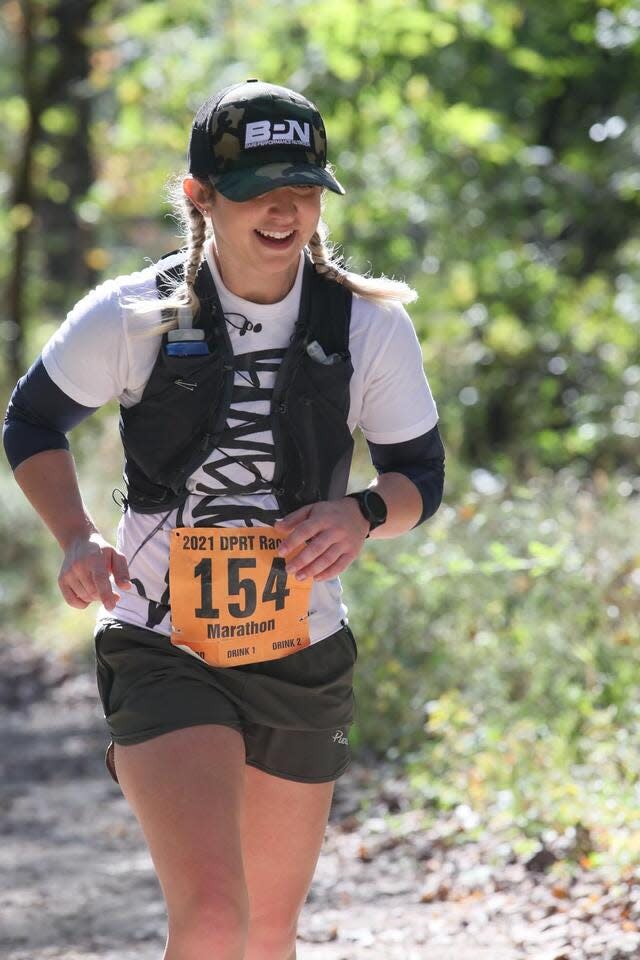 Katina DeJarnett in athletic clothes and a race bib on a trail marathon.