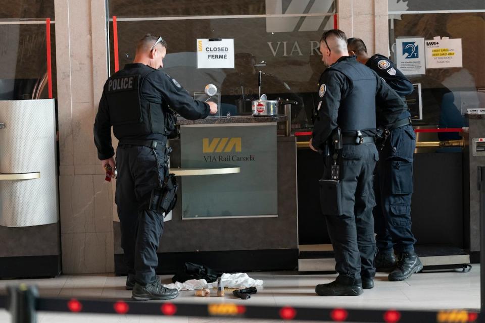 Police examine a suspicious package that forced the evacuation of Union Station in Toronto. (Arlyn McAdorey/The Canadian Press - image credit)
