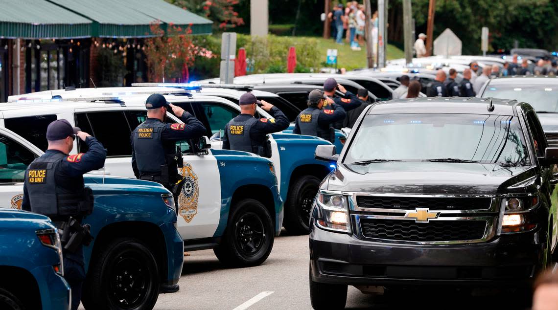 K9 officers salute as a procession for slain Wake County Sheriffís Deputy Ned Byrd comes down Glenwood Avenue past the Five Points neighborhood in Raleigh, N.C., Friday, August 19, 2022.