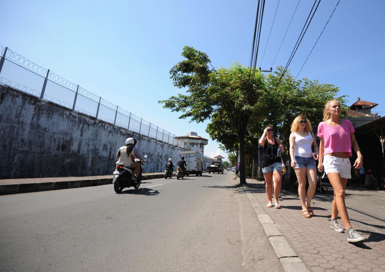 Tourists walk along a street in Denpasar, where an American woman allegedly threw her baby from a moving car (AFP/Getty Images)