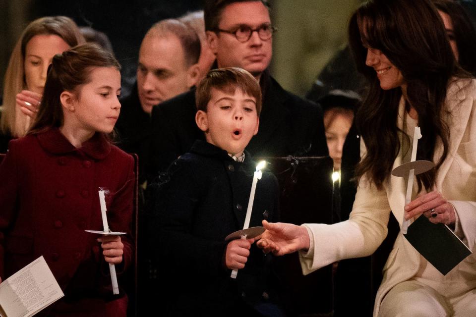 Prince Louis attempts to blow out his candle as the Princess of Wales watches on (PA)