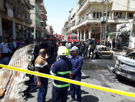 Iraqi security forces and firefighters gather at the site of car bomb attack near a government office in Karkh district in Baghdad, Iraq, May 30, 2017. REUTERS/Khalid al-Mousily