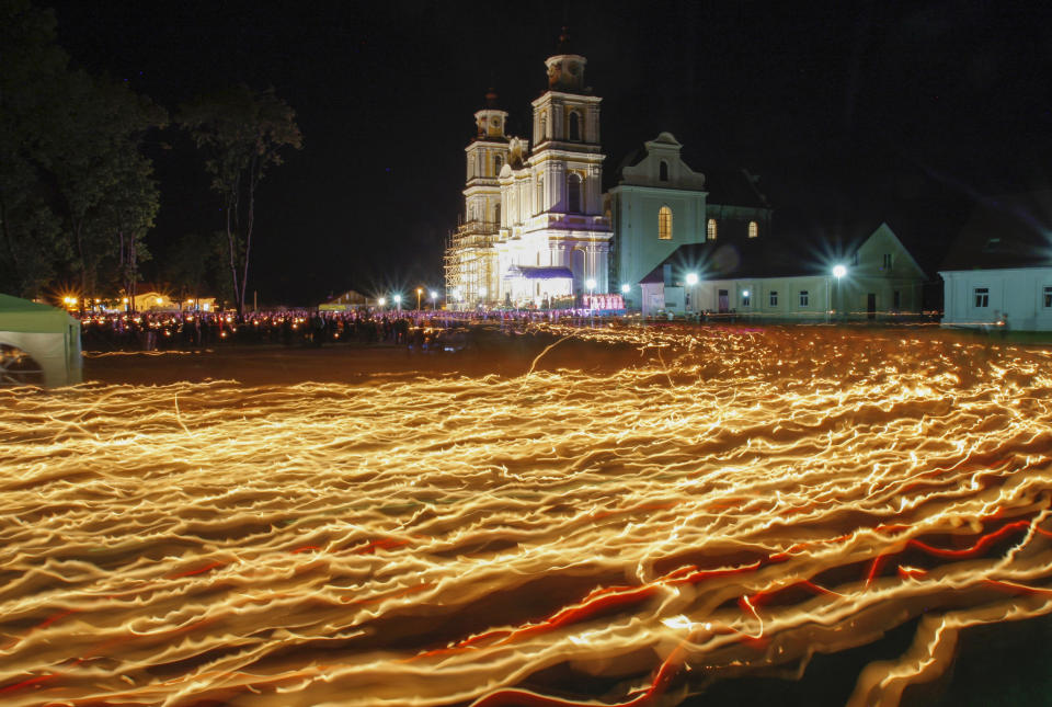 FILE - Catholic faithful from Belarus and neighboring countries carry candles at a festival honoring an icon known as the Mother of God of Budslav in the Belarus village of Budslav, some 150 kilometers (93 miles) north of Minsk, Belarus, on Friday, July 2, 2010. Dozens of clergymen in Belarus — Catholic, Orthodox and Protestant alike — have been jailed, silenced or forced into exile amid a crackdown by authorities following the disputed 2020 election that gave authoritarian President Alexander Lukashenko a sixth term. (AP Photo, File)