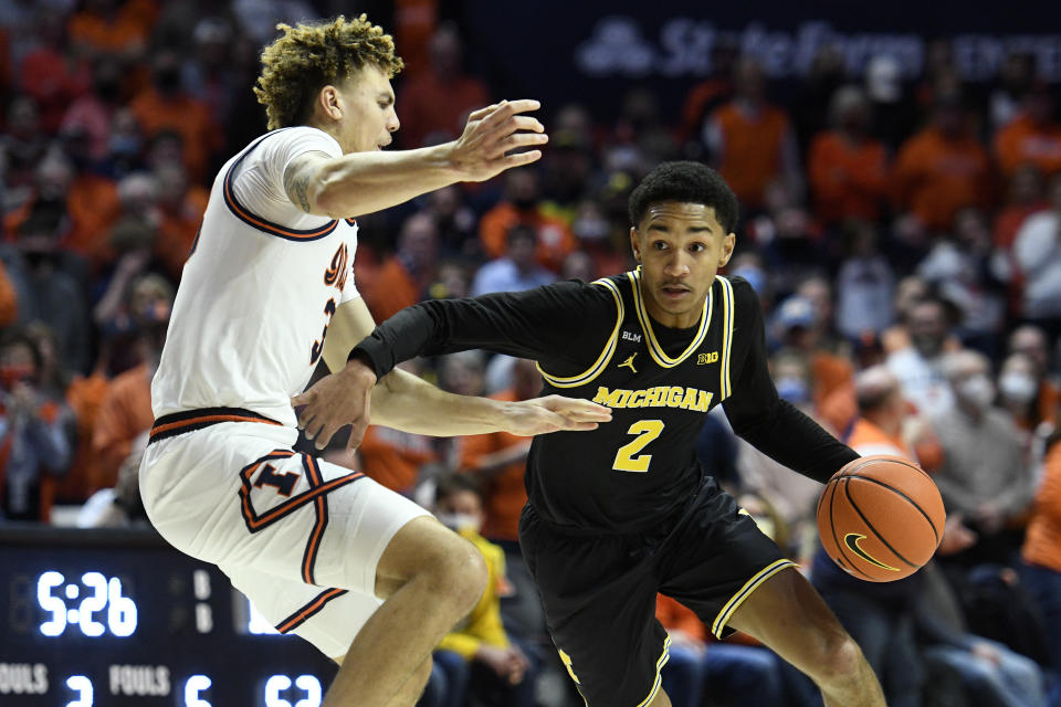 Michigan's Kobe Bufkin (2) dribbles as Illinois' Coleman Hawkins defends during the second half of an NCAA college basketball game Friday, Jan. 14, 2022, in Champaign, Ill. (AP Photo/Michael Allio)