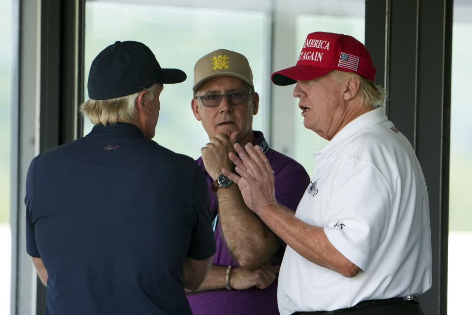 Former President Donald Trump talks with Greg Norman, LIV Golf CEO, left, and Paul Myler, deputy head of mission for the Australian Embassy in Washington, center, during the second round of the LIV Golf at Trump National Golf Club, Saturday, May 27, 2023, in Sterling, Va. (AP Photo/Alex Brandon)