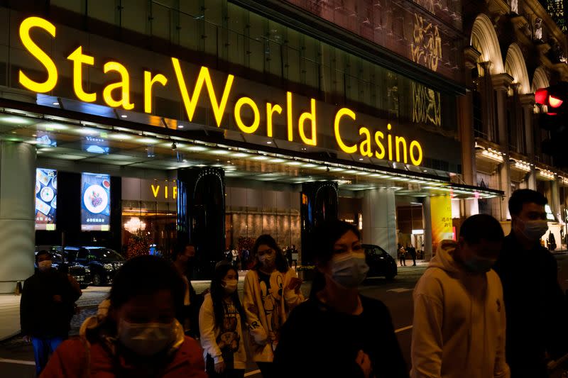 People wearing masks walk in front of StarWorld Casino, before its temporary closing, following the coronavirus outbreak in Macau