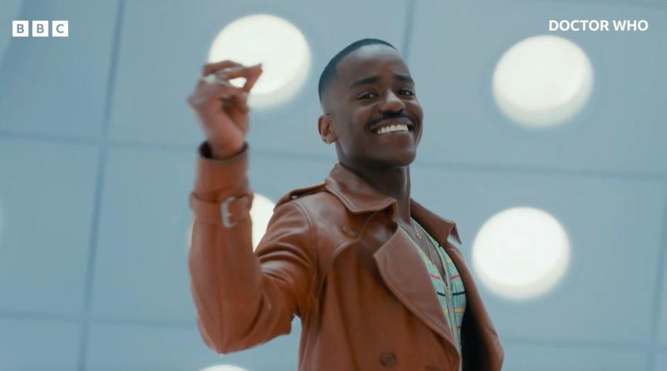 ncuti gatwa, as the fifteenth doctor on doctor who, smiles and lifts the fingers of his right hand in a snapping motion