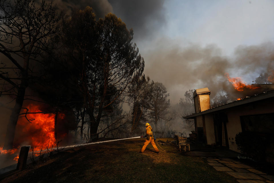 <p>A firefighter tries to save a home from the Skirball fire on December 6 in Bel-Air, California.</p>