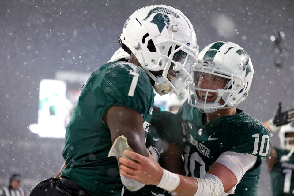 Michigan State's Jayden Reed, left, and quarterback Payton Thorne celebrate Reed's 20-yard touchdown catch on fourth down against Penn State during the fourth quarter Saturday, Nov. 27, 2021, in East Lansing, Mich. The Spartans won, 30-27.