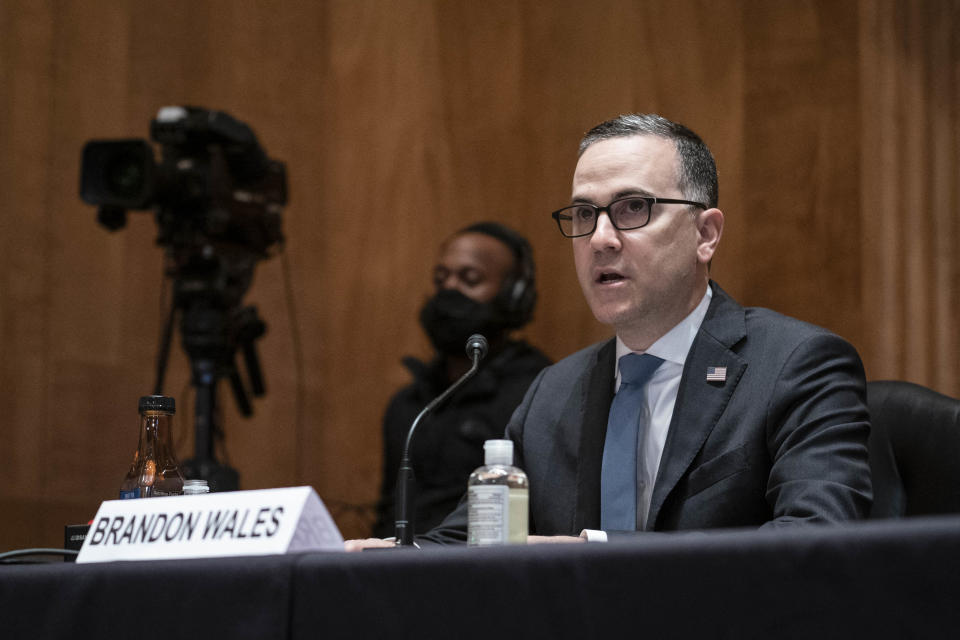 Brandon Wales speaks into a microphone at a hearing