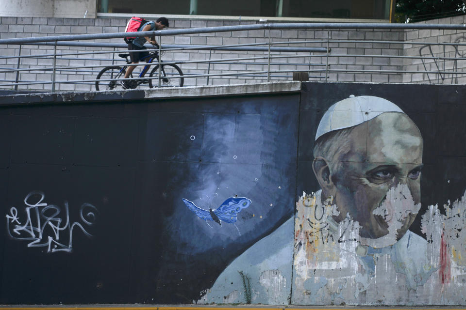 ARCHIVO - Un ciclista se desplaza por una rampa cerca de un mural del papa Francisco, en Buenos Aires, Argentina, el jueves 2 de marzo de 2023. Francisco salió de Argentina en febrero de 2013 para asistir al cónclave en la que fue elegido el sucesor de Benedicto XVI el 13 de marzo. (AP Foto/Natacha Pisarenko, Archivo)