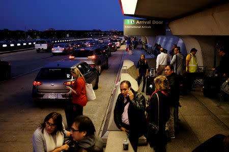 International passengers wait for their rides outside the international arrivals exit at Washington Dulles International Airport in Dulles, Virginia, U.S. September 24, 2017. REUTERS/James Lawler Duggan