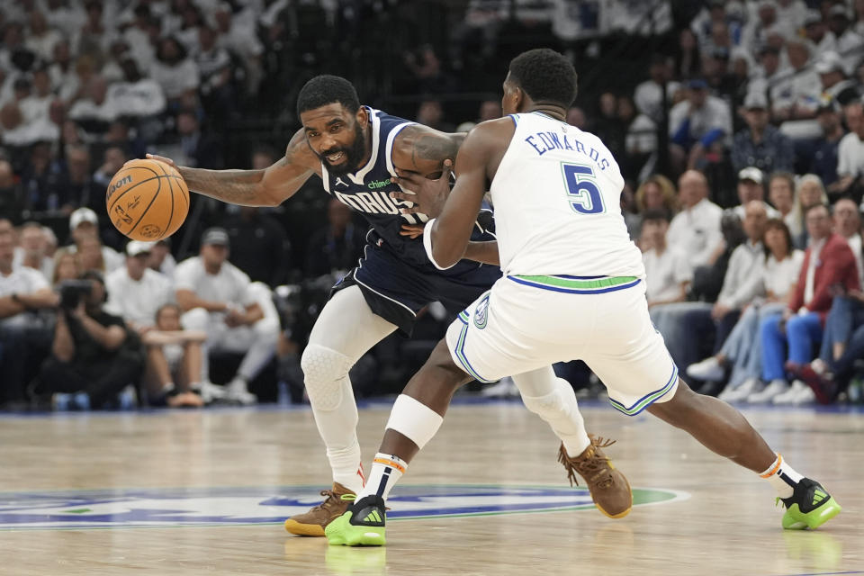 Dallas Mavericks guard Kyrie Irving, left, drives around Minnesota Timberwolves guard Anthony Edwards (5) during Game 1 of the NBA basketball Western Conference finals, Wednesday, May 22, 2024, in Minneapolis. (AP Photo/Abbie Parr)