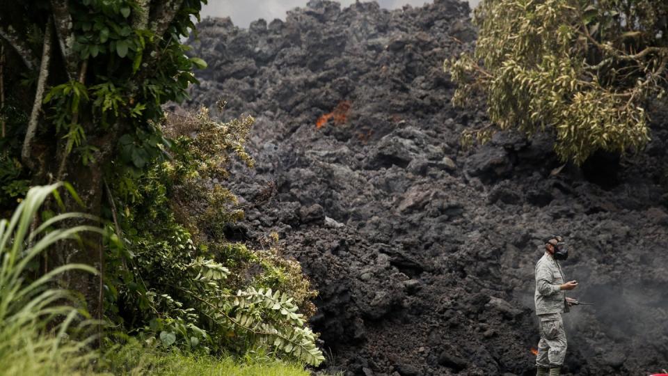 Der Kilauea Vulkan auf Hawaii gibt keine Ruhe. Ein Soldat der US Air Force neben einer Wand aus Lava. Seit Anfang Mai speit er auf Big Island in Hawaii Lava aus dem Krater und aus Erdspalten. Foto: Jae C. Hong/AP