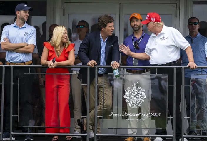 From left: Eric Trump, Rep. Marjorie Taylor Greene (R-Ga.), Tucker Carlson, Donald Trump Jr. and former President Donald Trump at Trump National Golf Club in Bedminster, N.J., July 31, 2022. (Doug Mills/The New York Times)