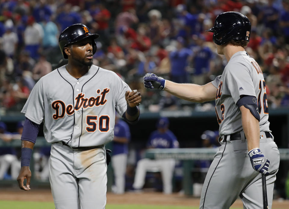 Detroit Tigers' Travis Demeritte (50) and Brandon Dixon (12) celebrate after Demeritte scored during the ninth inning of the team's baseball game against the Texas Rangers in Arlington, Texas, Friday, Aug. 2, 2019. (AP Photo/Tony Gutierrez)